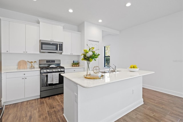 kitchen featuring white cabinetry, a center island with sink, sink, and appliances with stainless steel finishes