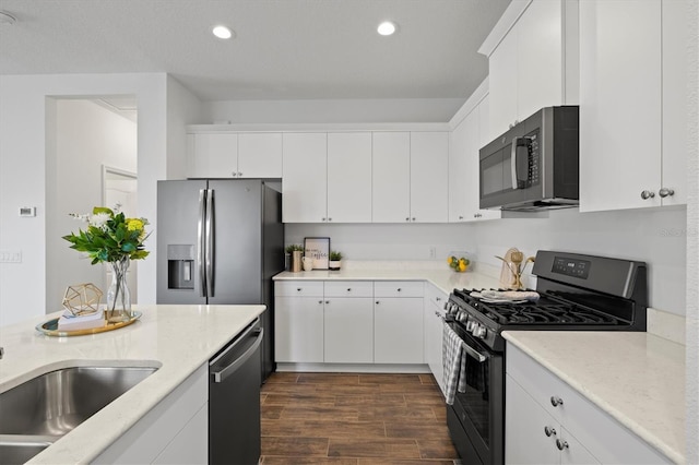 kitchen featuring light stone countertops, appliances with stainless steel finishes, and white cabinetry