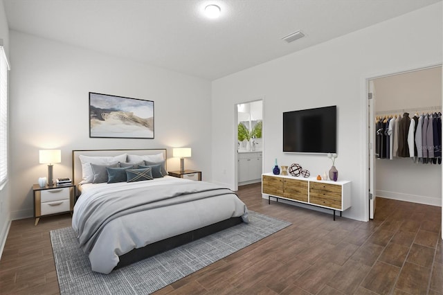 bedroom with a closet, ensuite bath, and a spacious closet