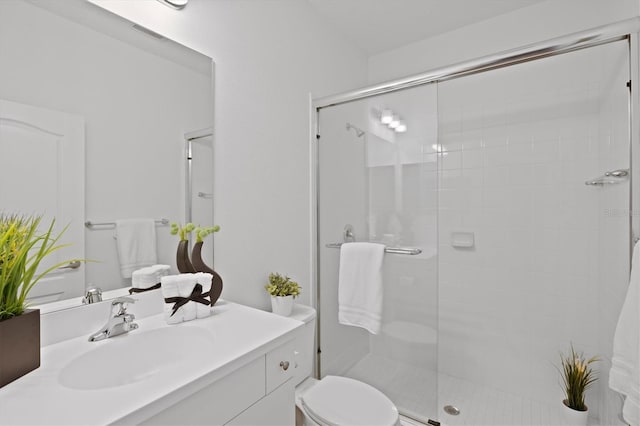 bathroom featuring vanity, an enclosed shower, and toilet