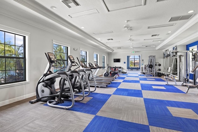 gym featuring ornamental molding, a textured ceiling, and a tray ceiling