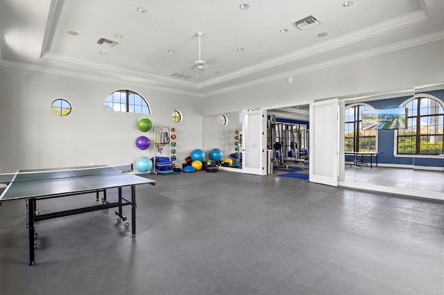 playroom featuring a tray ceiling, ceiling fan, crown molding, and a healthy amount of sunlight