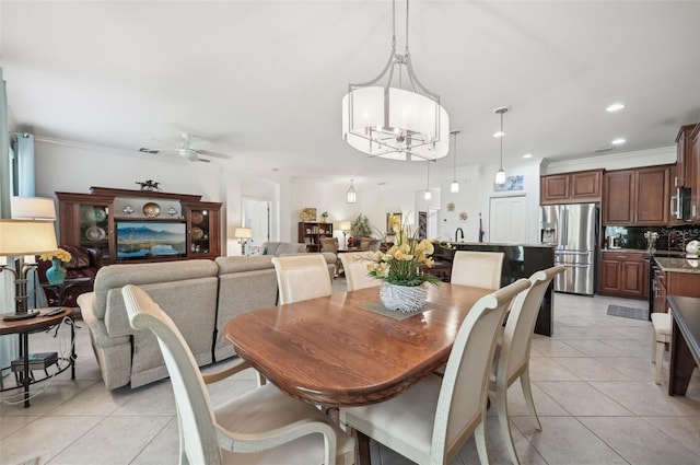 dining space featuring ceiling fan with notable chandelier, ornamental molding, and light tile patterned flooring