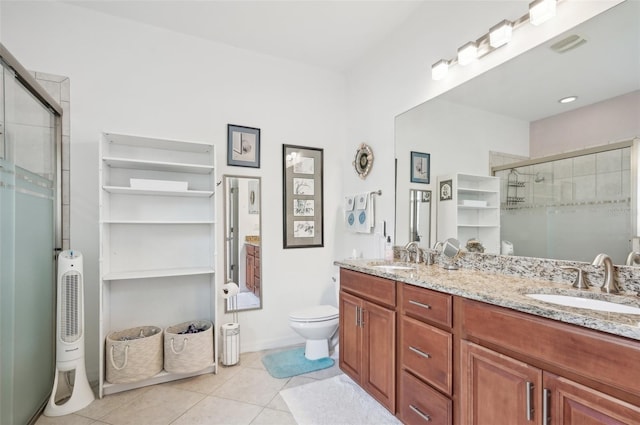 bathroom featuring tile patterned floors, vanity, toilet, and a shower with shower door