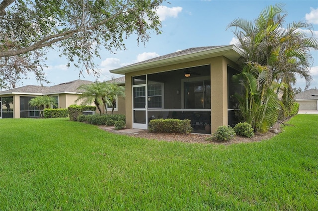 back of property featuring a sunroom and a yard