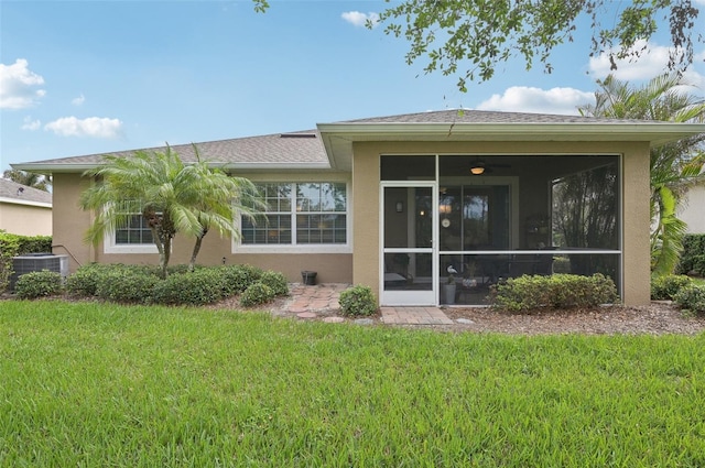 back of property with a lawn, a sunroom, and cooling unit