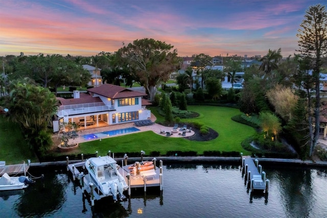 aerial view at dusk featuring a water view