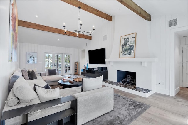 living room with vaulted ceiling with beams, light wood-type flooring, and a chandelier