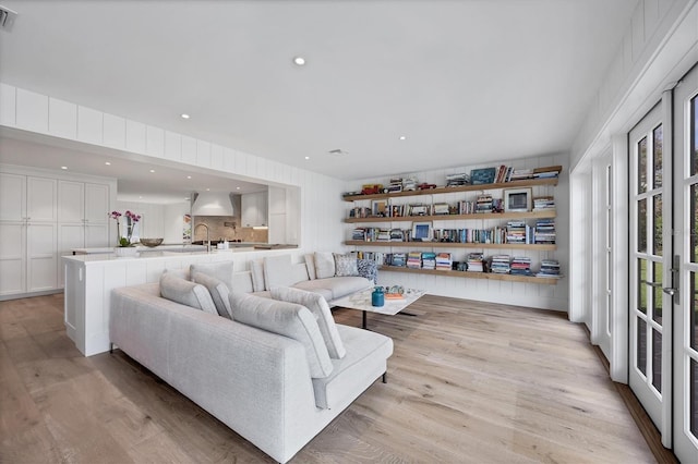 living room with light hardwood / wood-style flooring and sink