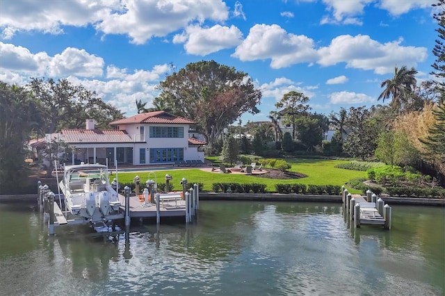 view of dock with a lawn and a water view