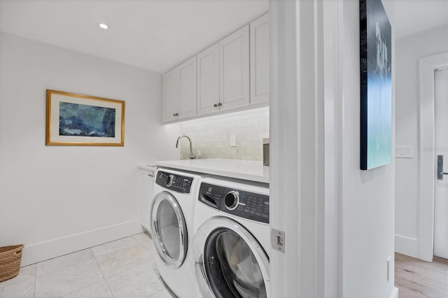 laundry room featuring separate washer and dryer, sink, and cabinets