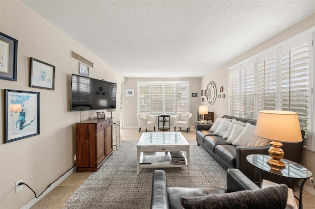 living room with light tile patterned floors, a textured ceiling, and a wealth of natural light