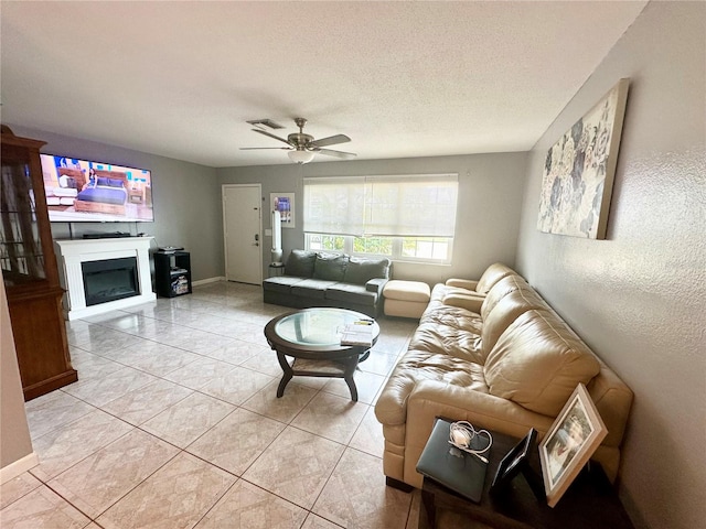 tiled living room featuring ceiling fan and a textured ceiling