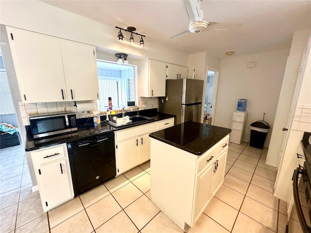 kitchen featuring tasteful backsplash, stainless steel appliances, a kitchen island, sink, and white cabinetry