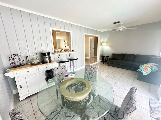 living room with ceiling fan, light tile patterned floors, and ornamental molding