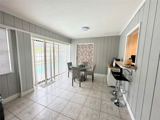 dining room with wood walls and ornamental molding