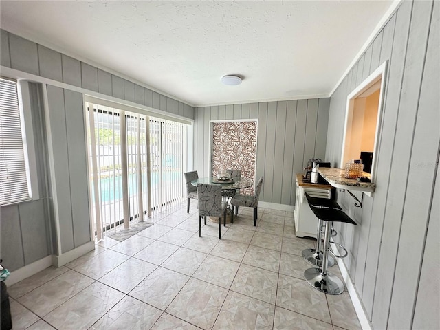108 Shell Rd, Venice, FL 34293 - dining room with baseboards, ornamental molding, a textured ceiling, and wooden walls