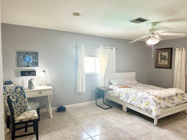 bedroom featuring ceiling fan, light tile patterned flooring, and a textured ceiling