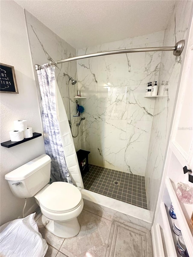 bathroom with tile patterned floors, curtained shower, toilet, and a textured ceiling