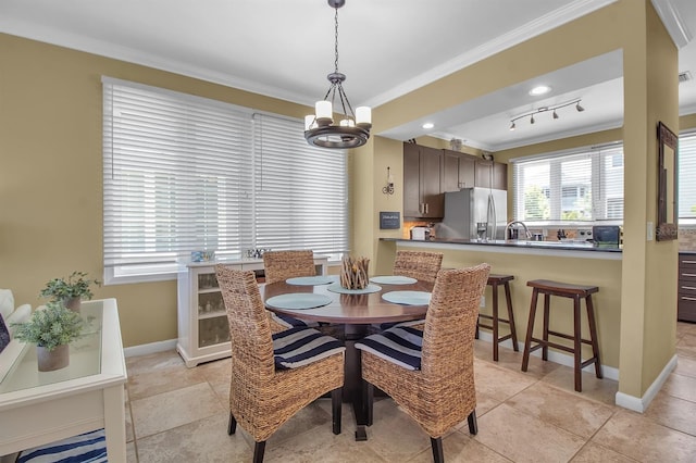 dining room with crown molding and a chandelier