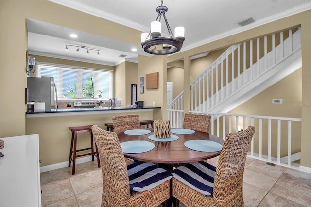 tiled dining room featuring a notable chandelier and ornamental molding