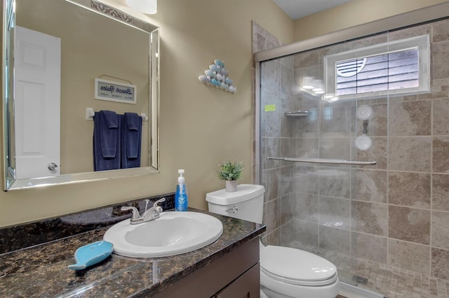 bathroom featuring walk in shower, vanity, and toilet