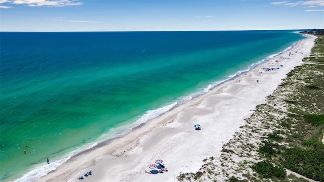 bird's eye view with a water view and a beach view