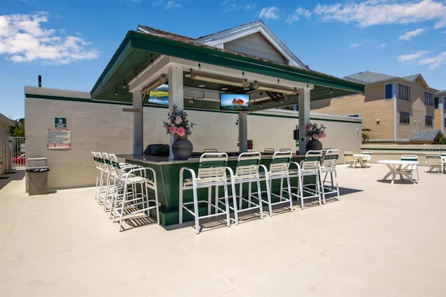 view of patio / terrace with a gazebo, ceiling fan, and exterior bar