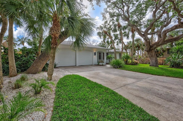 ranch-style home with a garage and a front yard