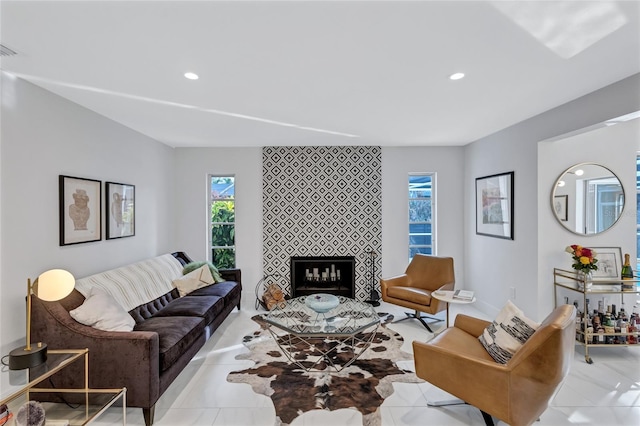 living room with a fireplace and light tile patterned floors