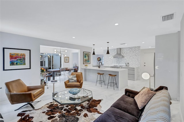 living room featuring a notable chandelier and sink