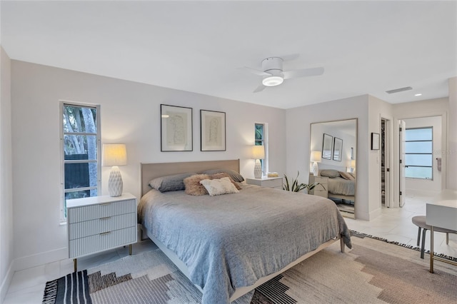 bedroom with ceiling fan, light tile patterned flooring, and ensuite bathroom