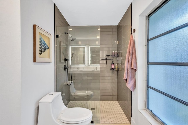 bathroom with a tile shower and toilet