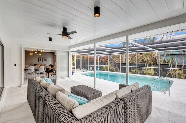 view of swimming pool featuring an outdoor living space, a patio area, and glass enclosure