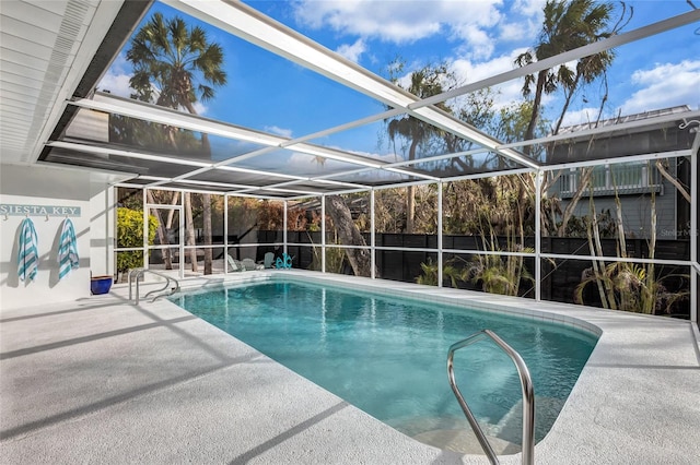 view of swimming pool featuring glass enclosure and a patio area