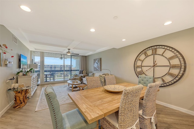 dining room featuring a wall of windows, ceiling fan, hardwood / wood-style flooring, and beamed ceiling