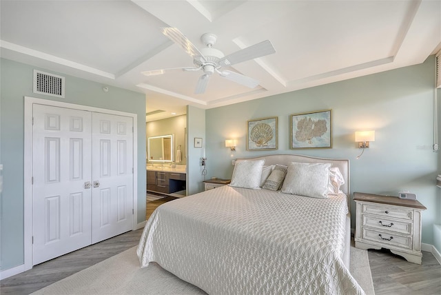 bedroom with ensuite bath, a closet, ceiling fan, and hardwood / wood-style flooring