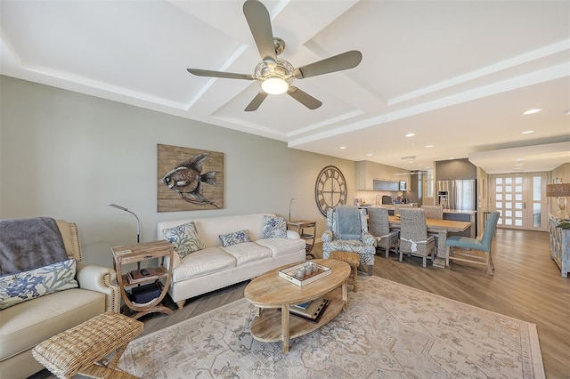 living room featuring coffered ceiling, ceiling fan, and light hardwood / wood-style floors