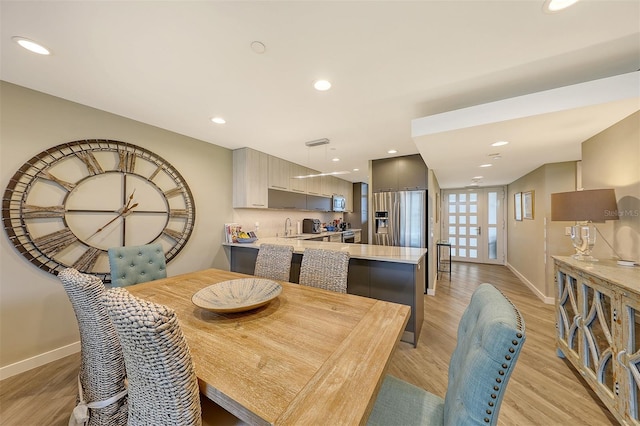 dining space featuring sink and light wood-type flooring