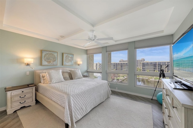 bedroom featuring coffered ceiling, beamed ceiling, ceiling fan, and light wood-type flooring