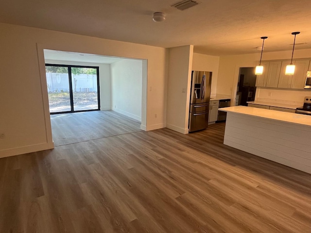 kitchen featuring appliances with stainless steel finishes, dark hardwood / wood-style floors, and pendant lighting