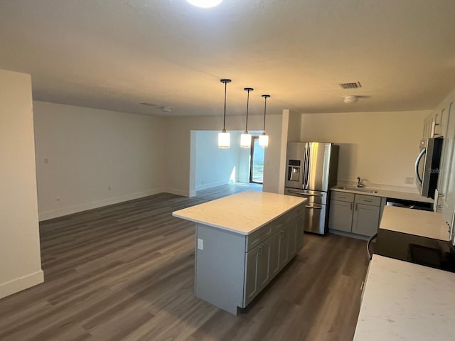 kitchen with a center island, dark hardwood / wood-style flooring, stainless steel refrigerator with ice dispenser, decorative light fixtures, and gray cabinets