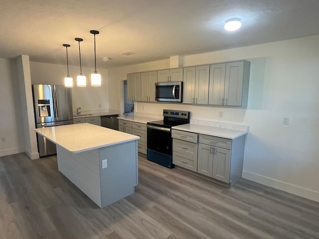 kitchen featuring pendant lighting, dark hardwood / wood-style flooring, a kitchen island, and black appliances