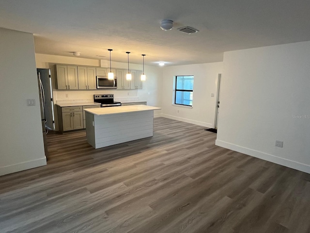 kitchen featuring pendant lighting, gray cabinetry, a kitchen island, dark hardwood / wood-style flooring, and stainless steel appliances