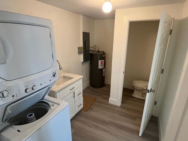 laundry area with stacked washer / drying machine, light hardwood / wood-style floors, electric water heater, and electric panel