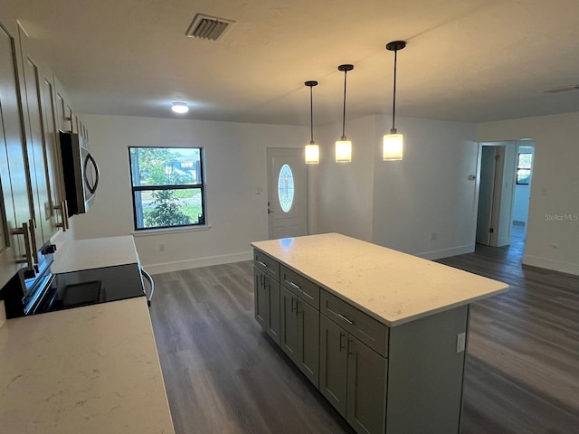 kitchen with range with electric cooktop, gray cabinetry, dark wood-type flooring, a center island, and hanging light fixtures