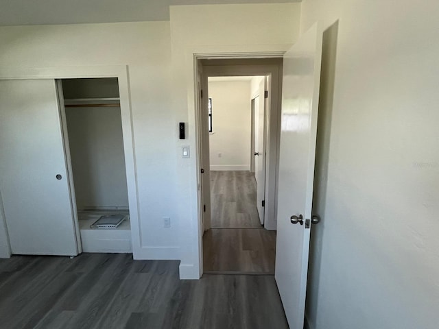 unfurnished bedroom featuring a closet and dark wood-type flooring