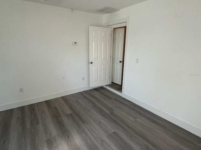 empty room with dark hardwood / wood-style flooring