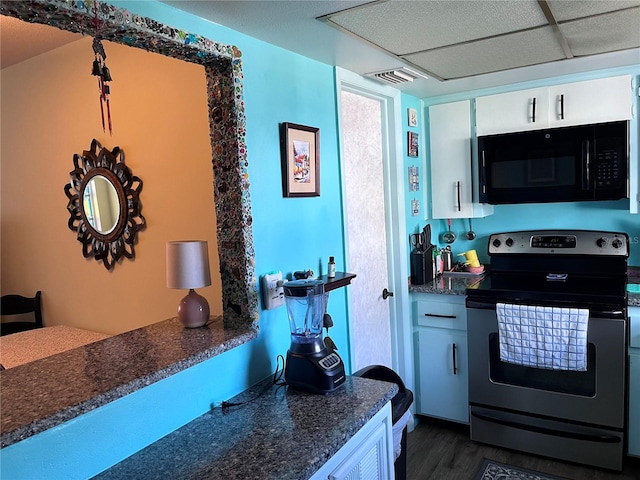 kitchen with white cabinetry, stainless steel electric range oven, a drop ceiling, and dark wood-type flooring