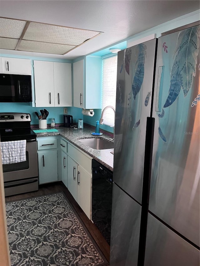 kitchen featuring white cabinets, sink, stone counters, and black appliances